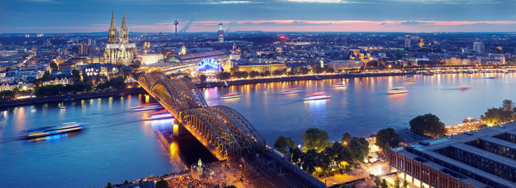 View of Colognge at night from above, over the river, with the cathedral showing at the end of the bridge