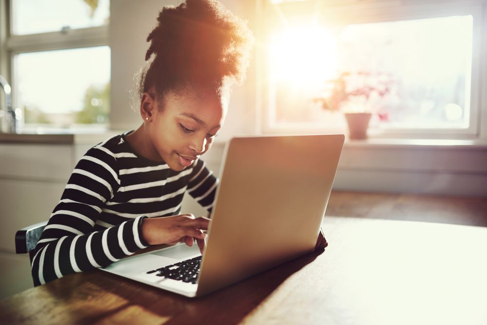 Girl using a laptop to study prealgebra 1 at her own pace