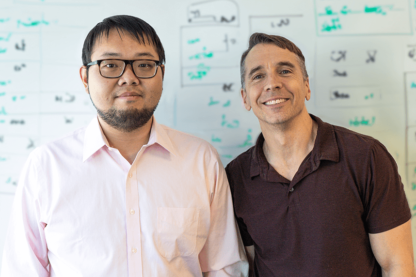 5-time IMO Gold Winner Alex Song and AoPS Founder Richard Rusczyk in front of a whiteboard with math notation